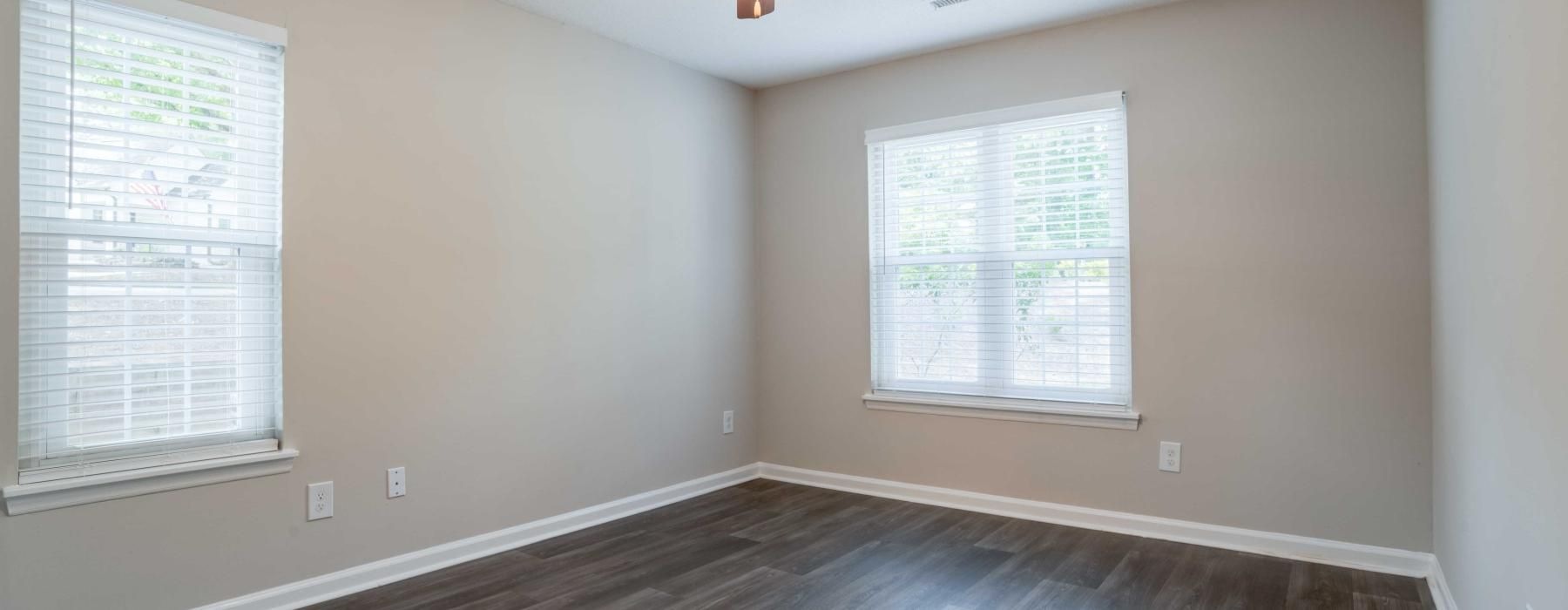 a room with a ceiling fan and a wood floor